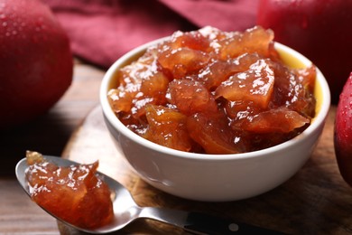 Photo of Delicious apple jam and fresh fruits on wooden table, closeup