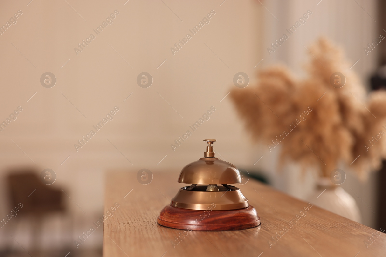 Photo of Service bell on wooden reception desk in hotel