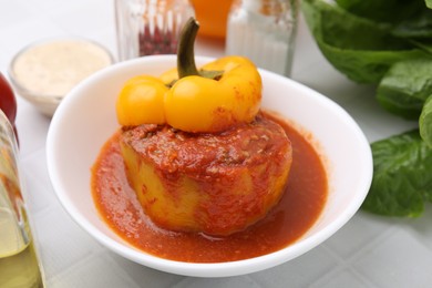 Photo of Delicious stuffed bell peppers on white tiled table, closeup