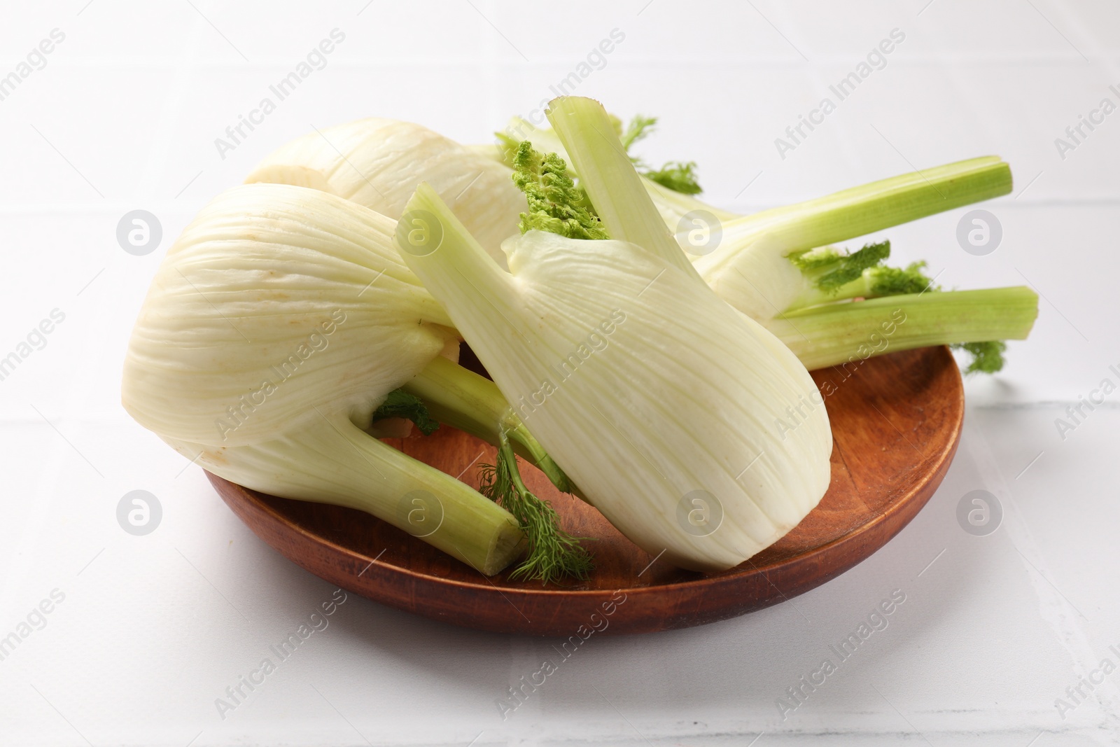 Photo of Fresh raw fennel bulbs on white table, closeup