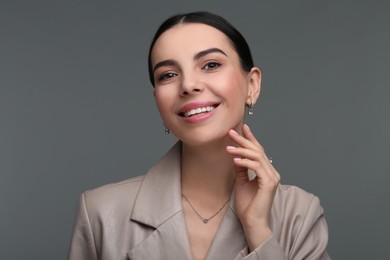 Photo of Young woman with elegant jewelry on dark grey background