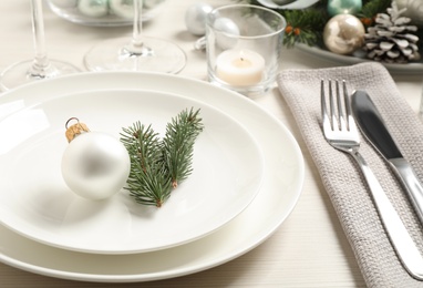 Photo of Festive table setting with beautiful dishware and Christmas decor on white wooden background