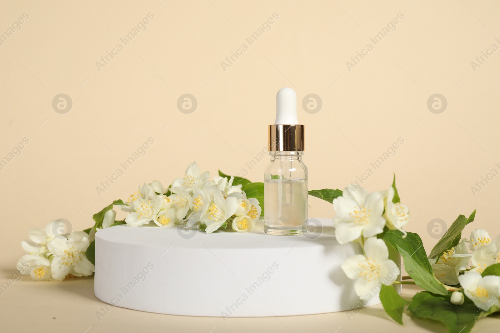 Photo of Presentation of essential oil in bottle and beautiful jasmine flowers against beige background