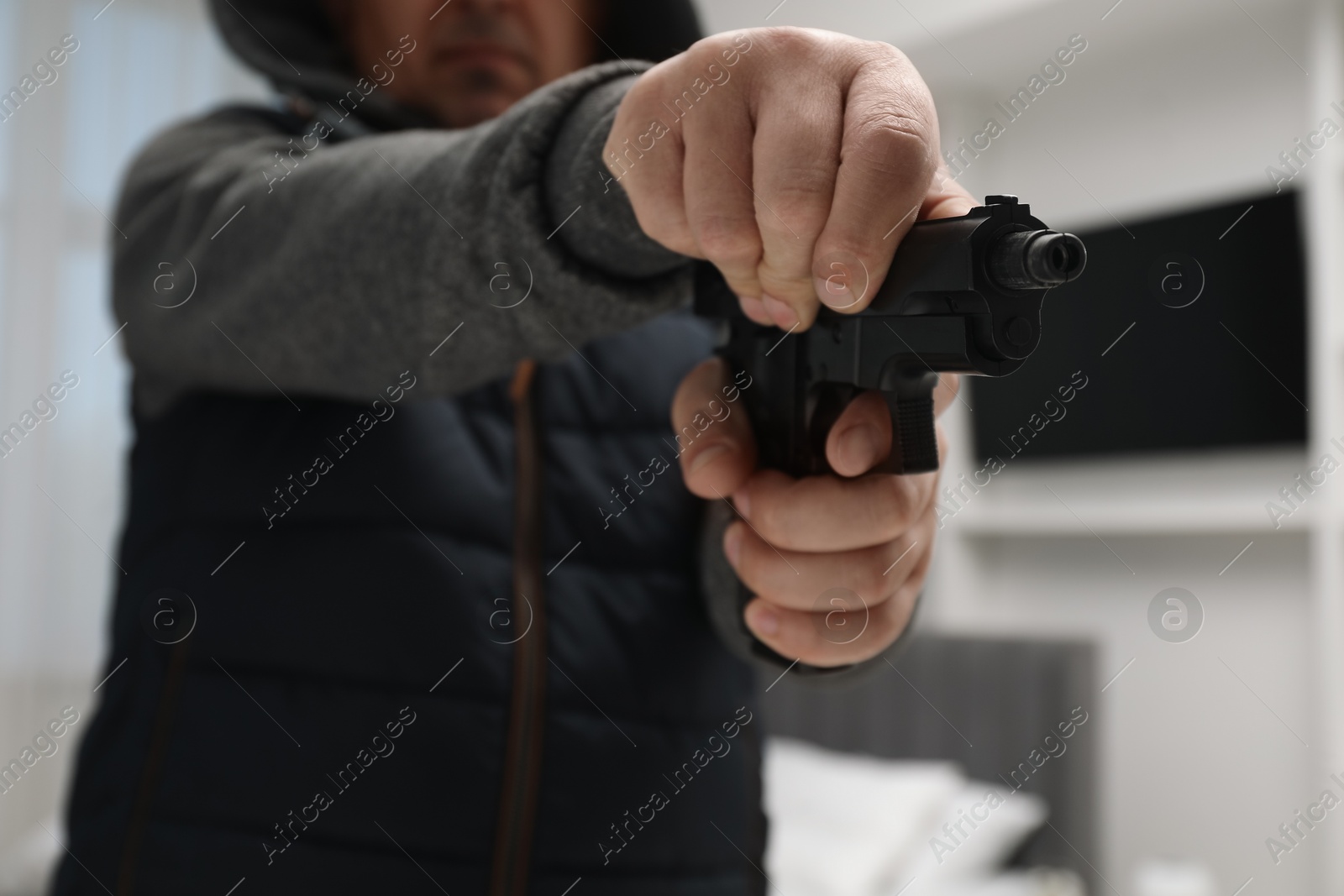 Photo of Dangerous criminal with gun in foreign house, selective focus. Armed robbery