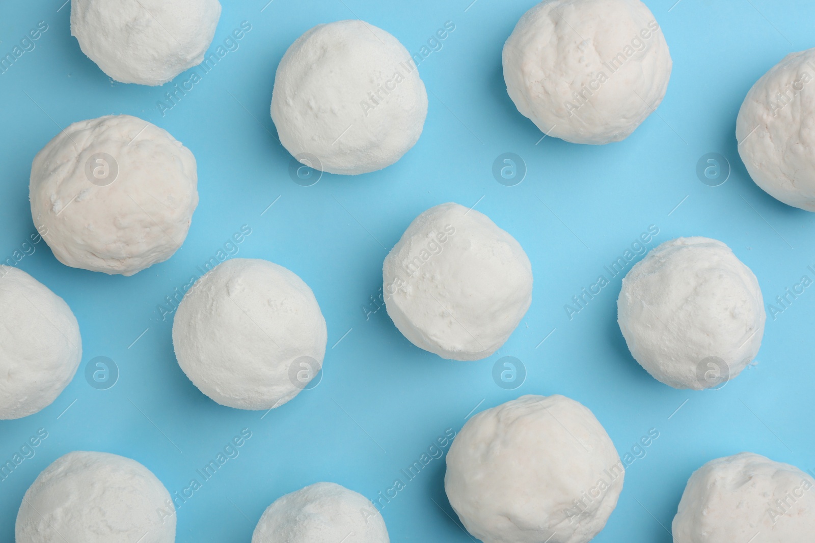 Photo of Round snowballs on light blue background, flat lay