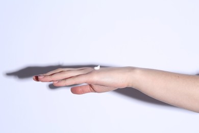 Photo of Woman with cream on her hand against white background, closeup