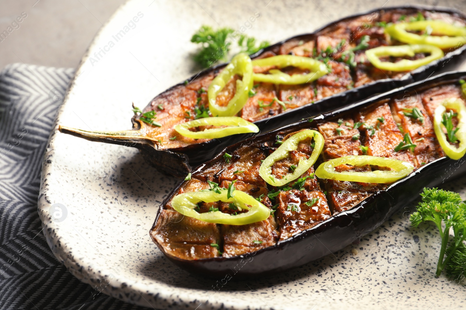 Photo of Fried eggplant slices with chili peppers on plate, closeup