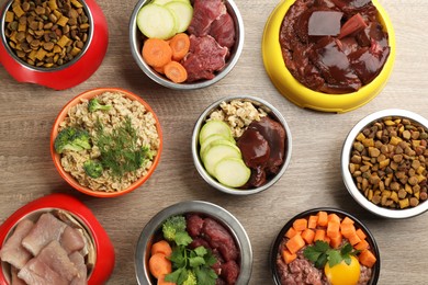 Photo of Pet food and natural ingredients on wooden table, flat lay