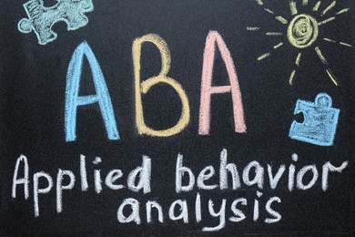 Photo of Text ABA Applied behavior analysis and drawings on blackboard