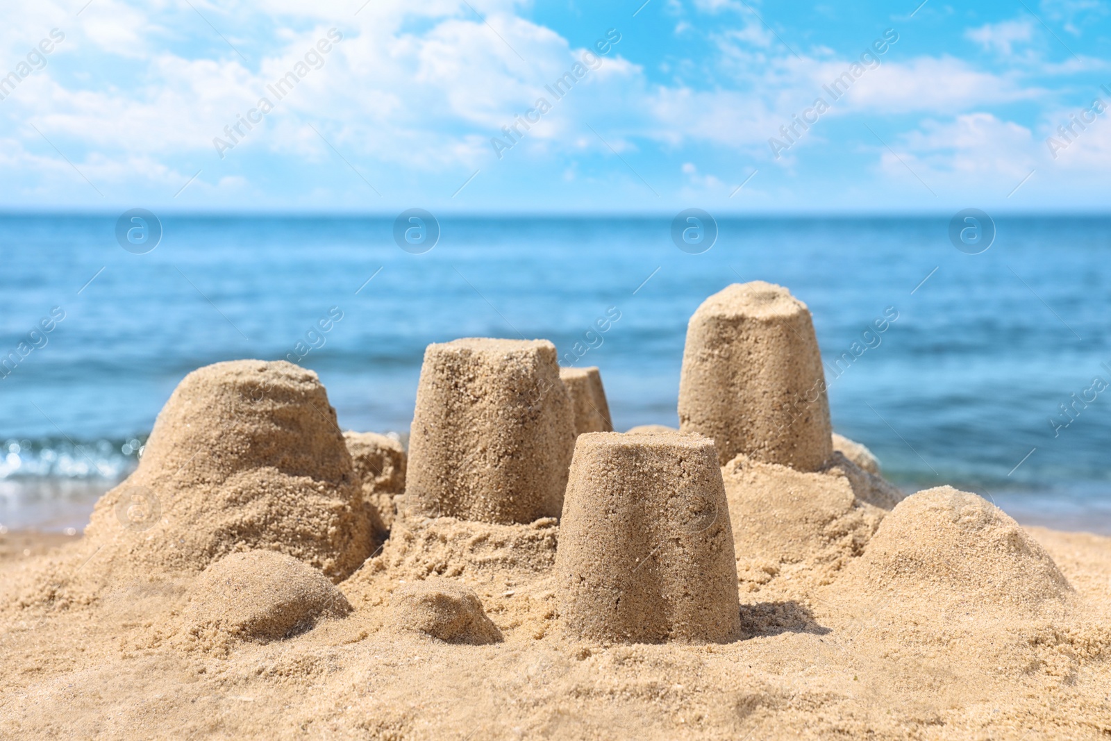 Photo of Little sand figures on beach near sea