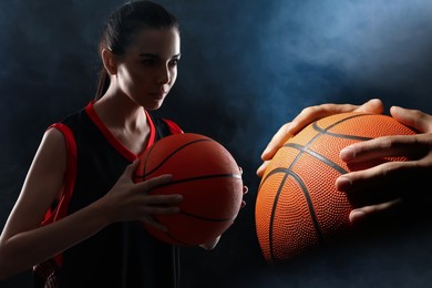 Basketball players with leather balls on dark background, collage