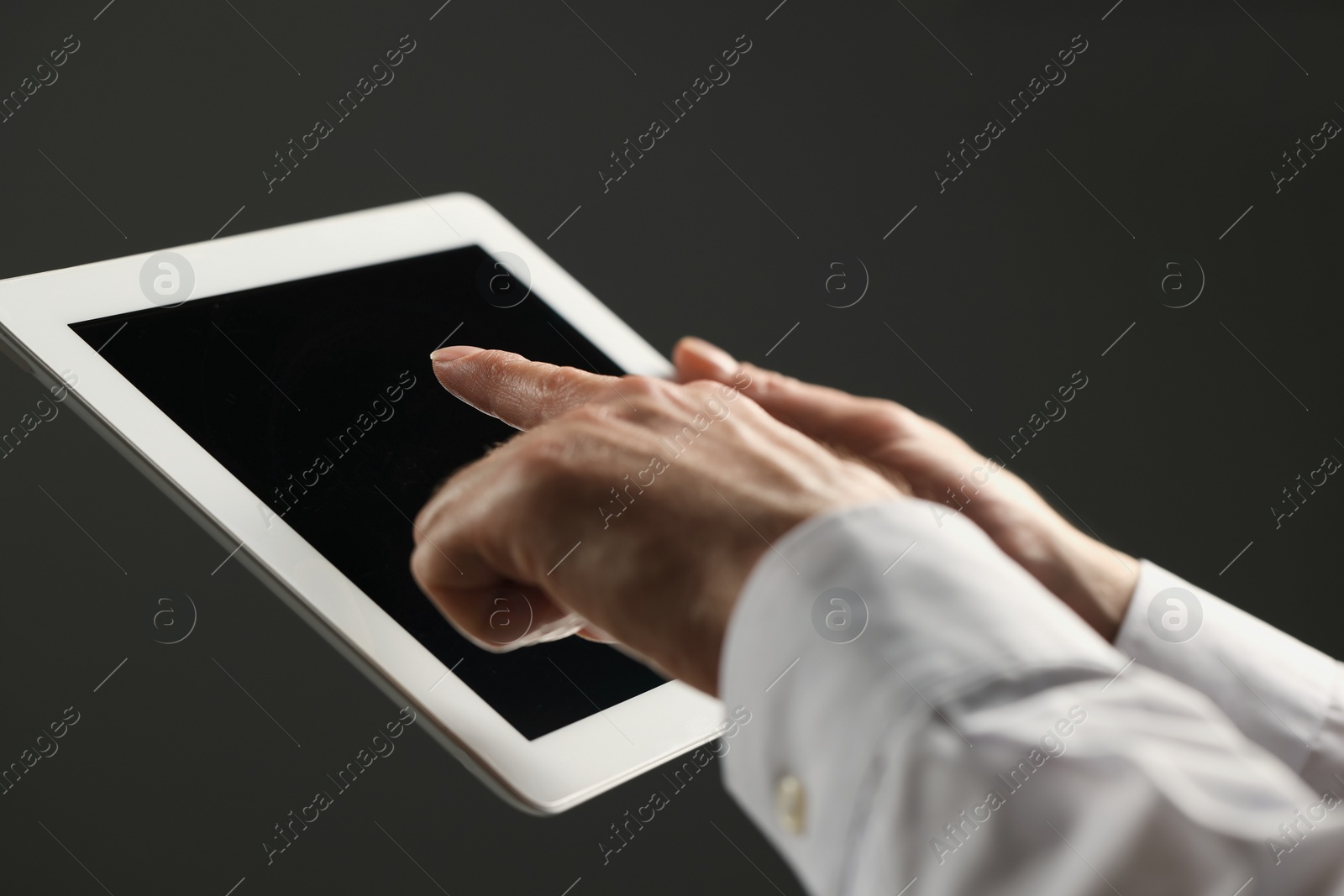 Photo of Closeup view of man using new tablet on grey background