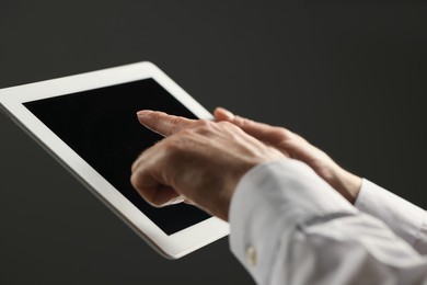 Closeup view of man using new tablet on grey background