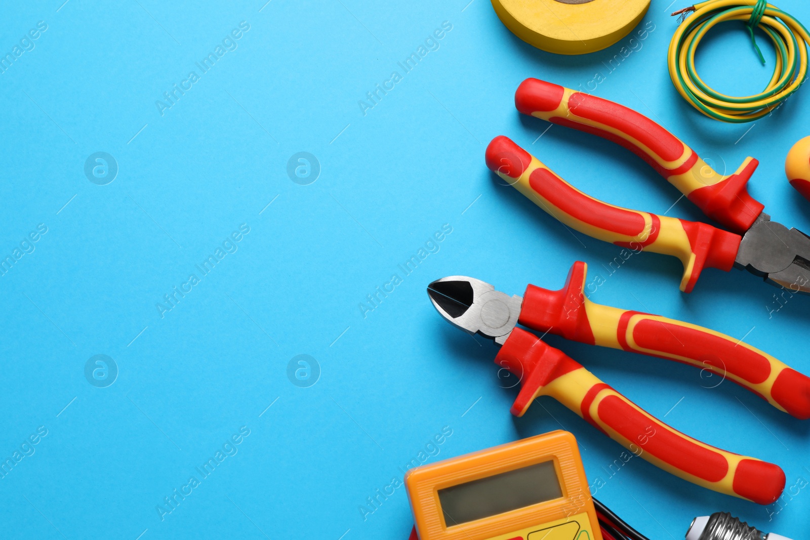 Photo of Flat lay composition with electrician's tools and accessories on light blue background, space for text