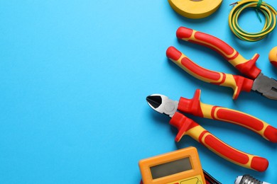 Photo of Flat lay composition with electrician's tools and accessories on light blue background, space for text