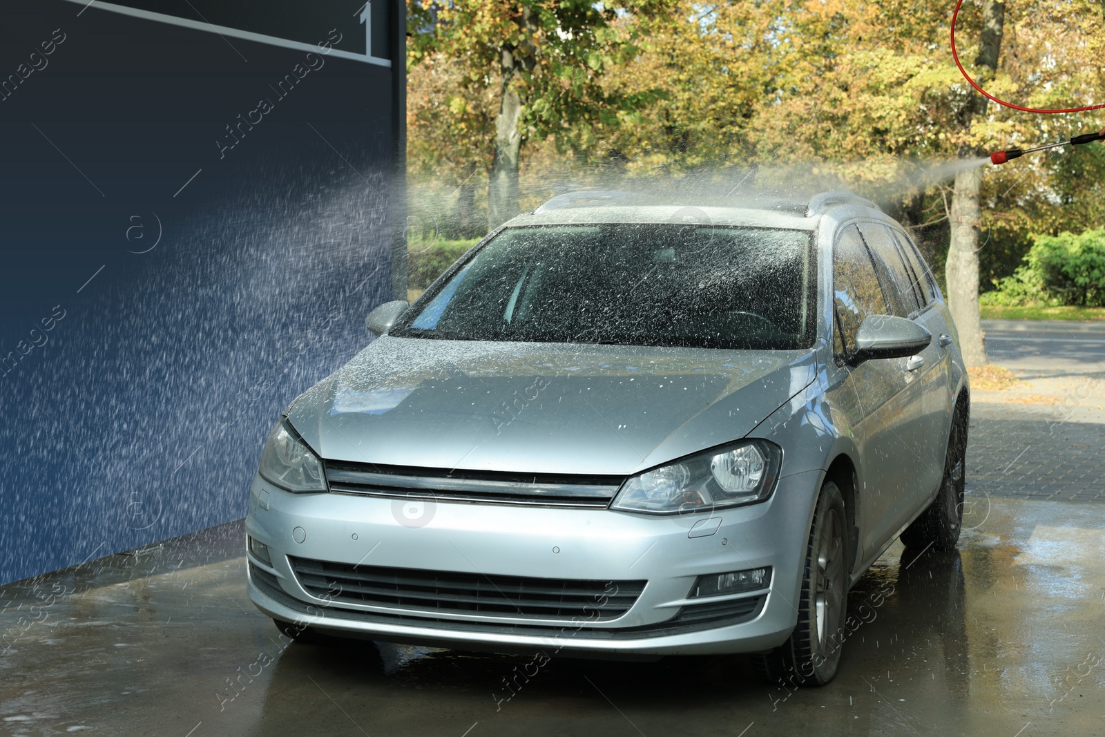 Photo of Washing auto with high pressure water jet at outdoor car wash