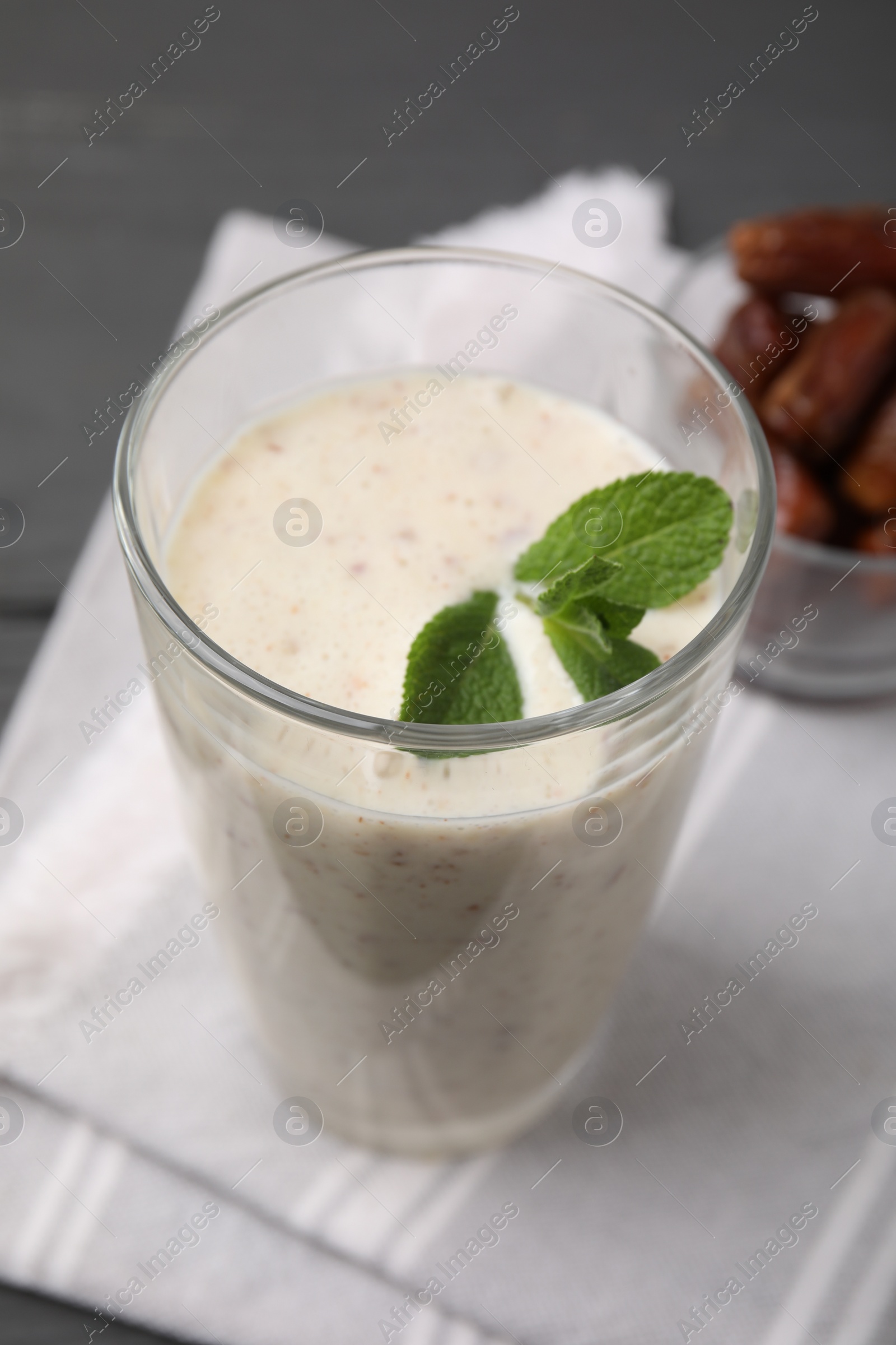 Photo of Glass of delicious date smoothie with mint on table, closeup