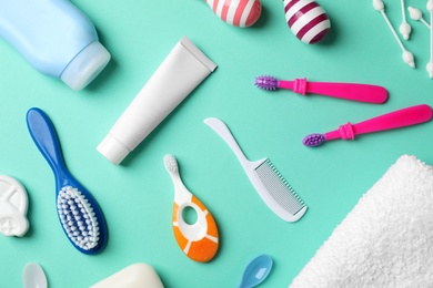 Flat lay composition with baby toothbrushes and toiletries on color background