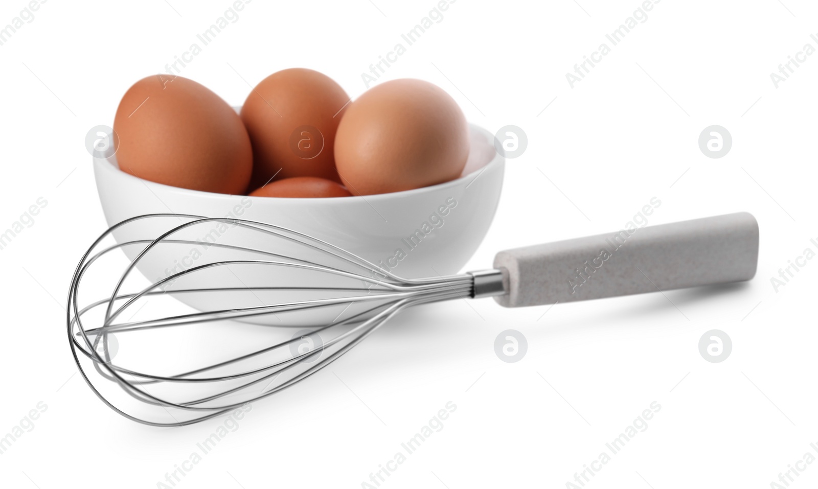 Photo of Whisk and bowl with raw eggs isolated on white