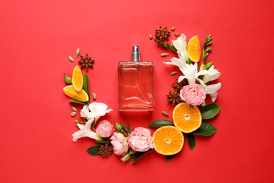 Flat lay composition with bottle of perfume and fresh citrus fruits on red background