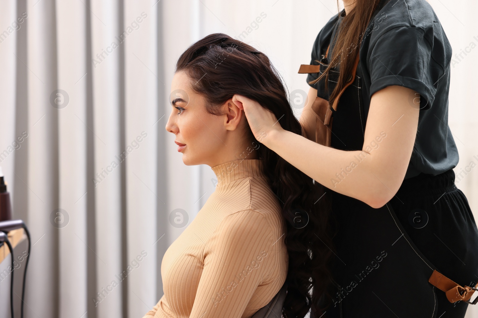 Photo of Hair styling. Professional hairdresser working with client indoors, closeup