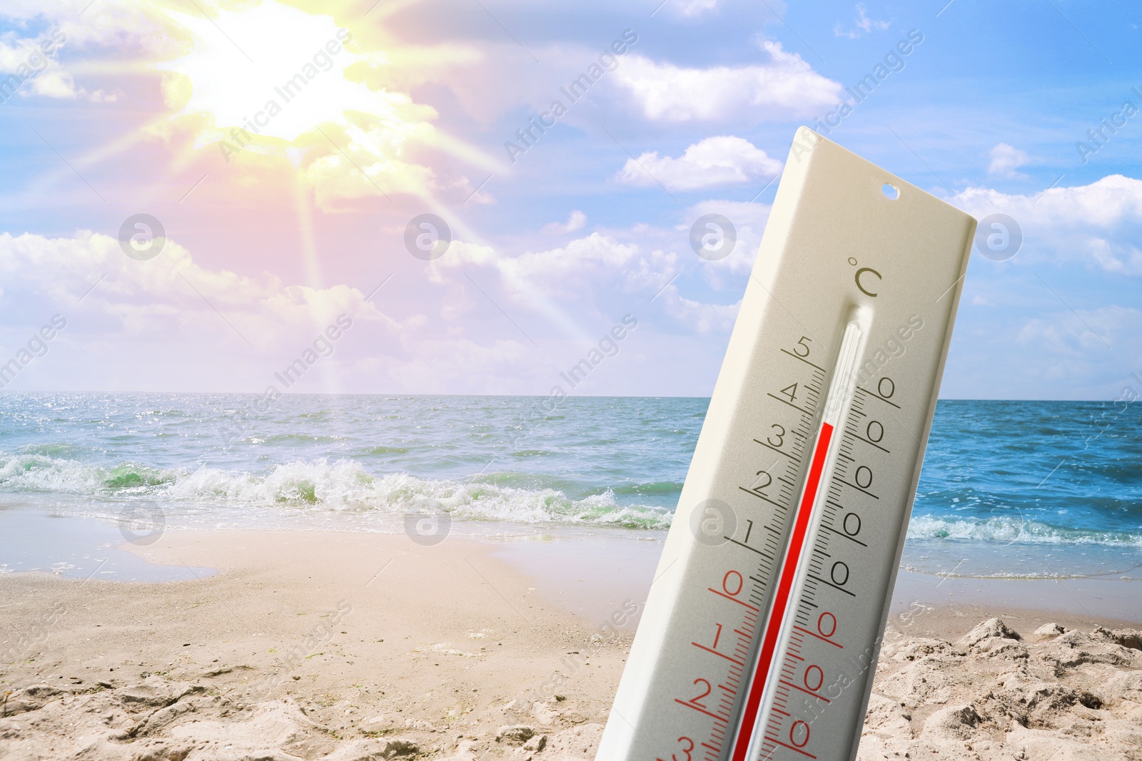 Image of Thermometer on beach showing high temperature during hot day in summer