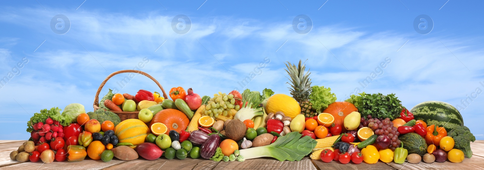 Image of Assortment of fresh organic fruits and vegetables on wooden table outdoors. Banner design