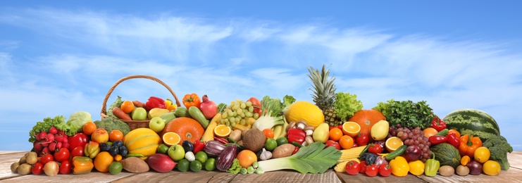 Assortment of fresh organic fruits and vegetables on wooden table outdoors. Banner design