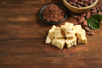 Composition with organic cocoa butter on wooden table. Space for text