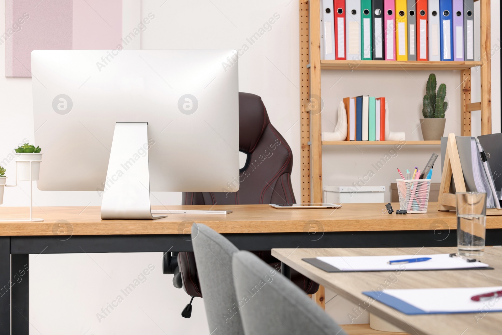 Photo of Director's office with large wooden table and comfortable armchairs. Interior design