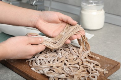 Photo of Woman making soba at table in kitchen, closeup