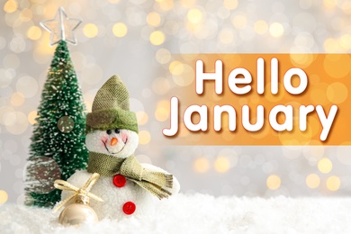 Image of Greeting card with text Hello January. Little toy snowman and fir tree on snow against blurred Christmas lights