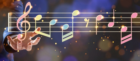 Image of Musician holding staff with music notes and symbols on color background, closeup. Banner design