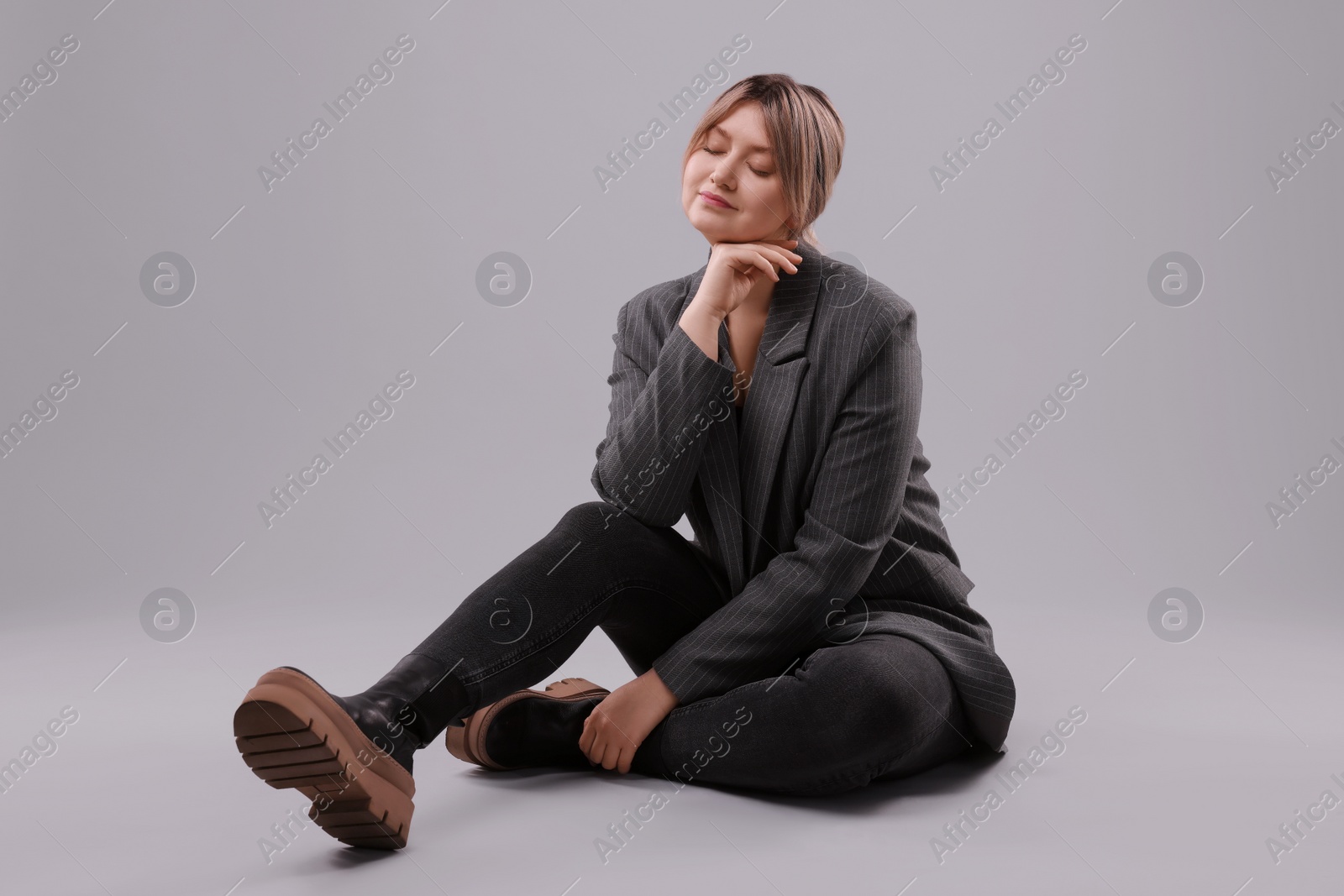 Photo of Beautiful young woman posing on grey background