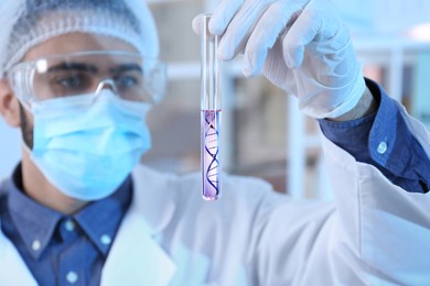 Image of Genetics research. Scientist holding test tube with liquid and illustration of DNA structure in laboratory, selective focus