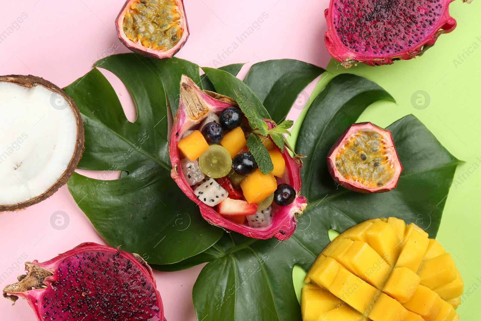 Photo of Flat lay composition with delicious exotic fruit salad on color background