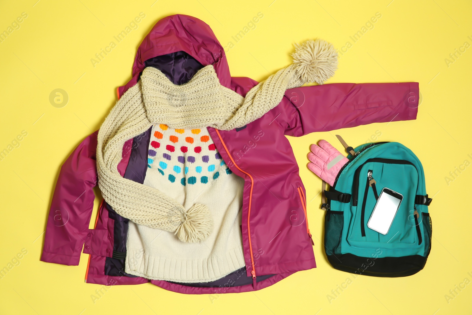 Photo of Flat lay composition with warm clothes for winter vacation on color background