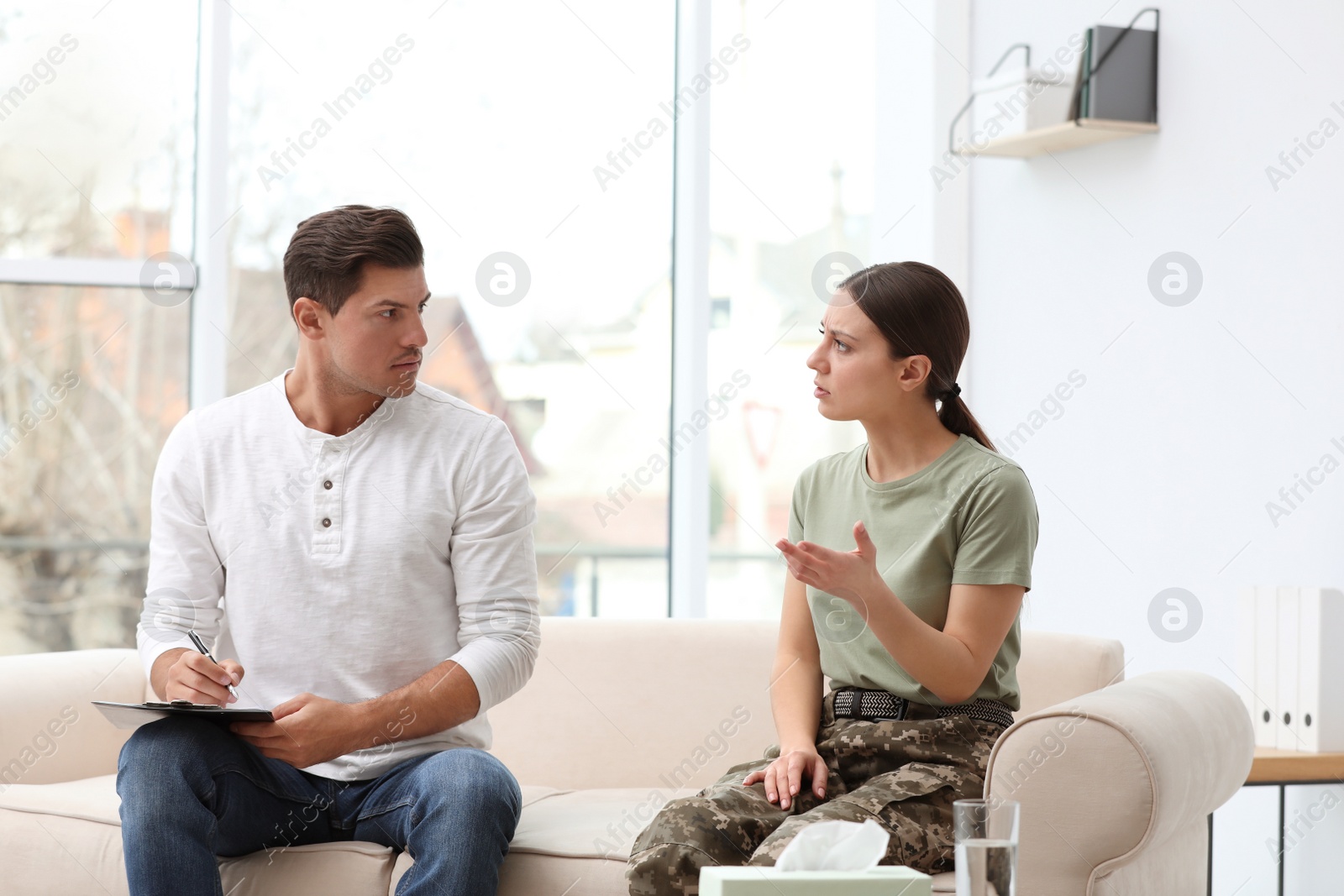 Photo of Psychotherapist working with female military officer in office