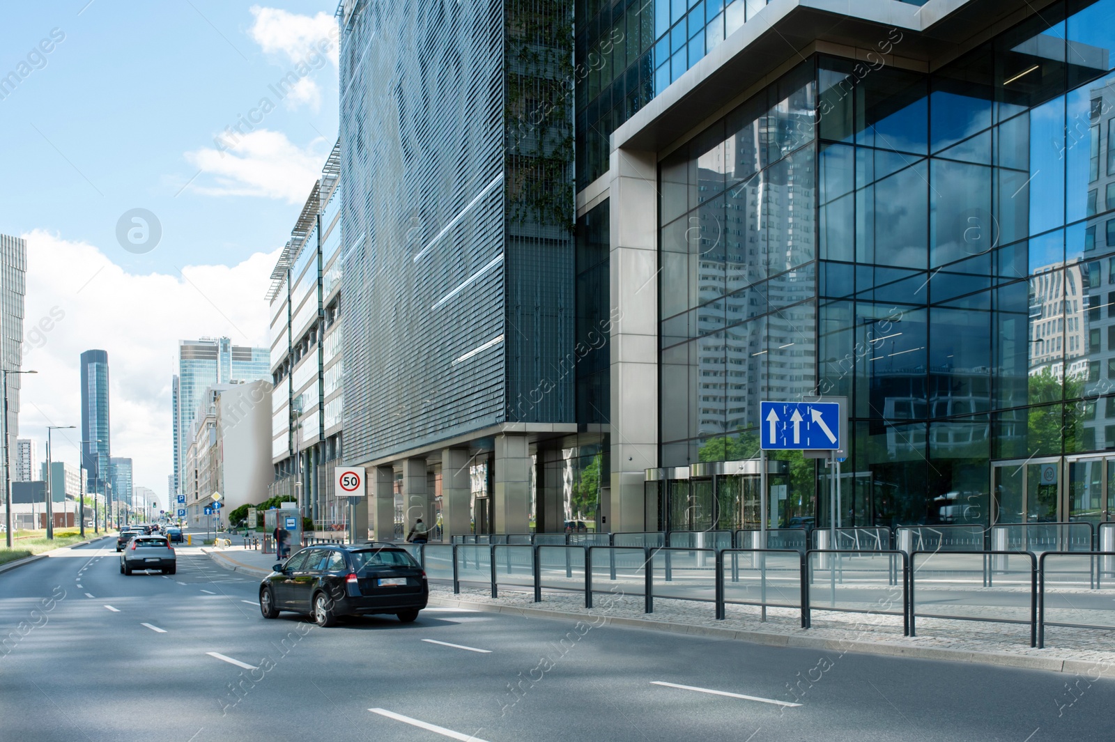 Photo of Road, cars and beautiful buildings on cloudy day in city