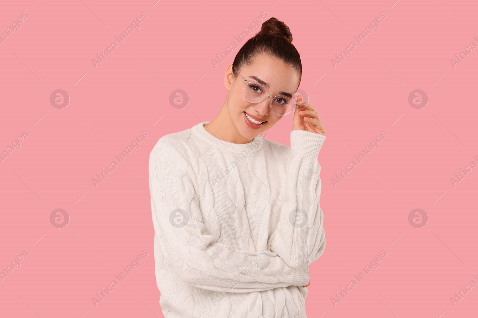 Photo of Beautiful young woman in stylish warm sweater on pink background