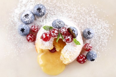Photo of Tasty vanilla fondant with white chocolate and berries on white table, flat lay