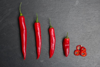 Flat lay composition with chili peppers on grey background