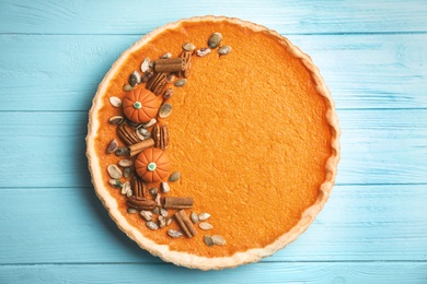Photo of Delicious homemade pumpkin pie on light blue wooden table, top view