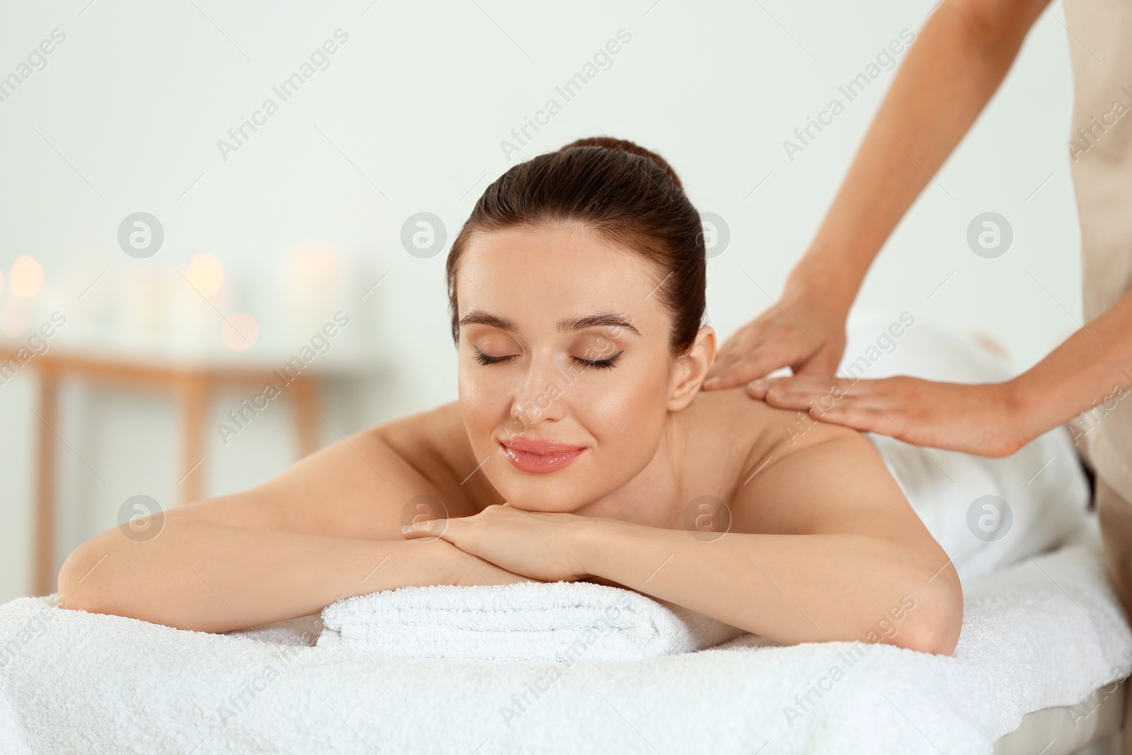 Photo of Beautiful young woman enjoying massage in spa salon