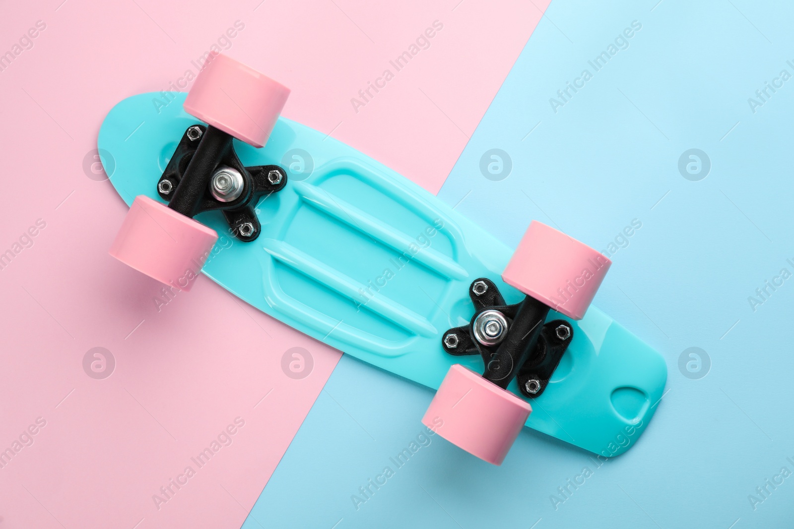 Photo of Turquoise skateboard on color background, top view