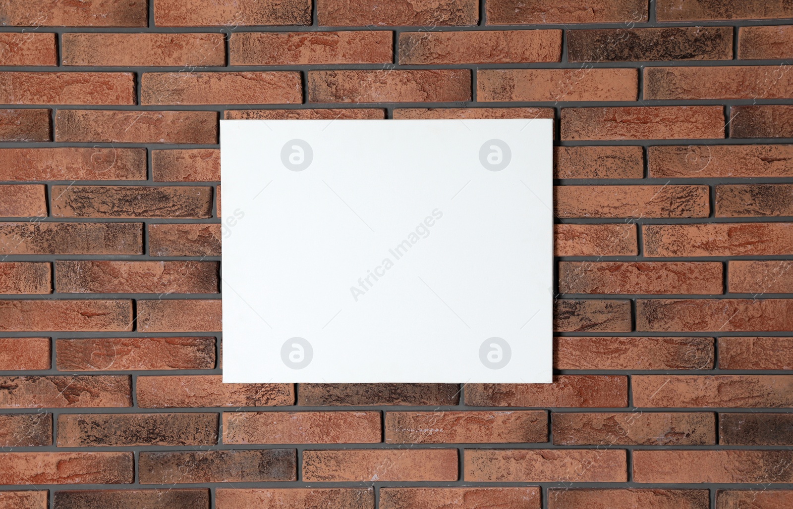 Photo of Blank canvas on brick wall. Space for design