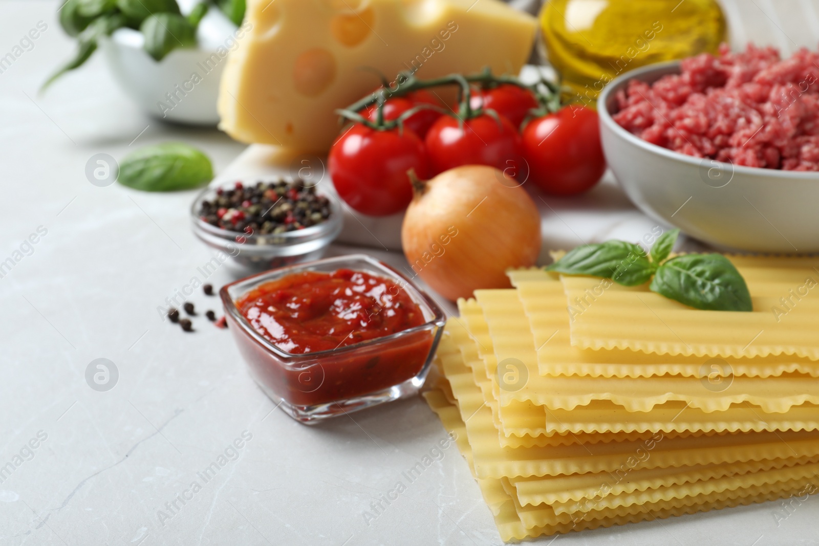 Photo of Fresh ingredients for lasagna on light grey marble table