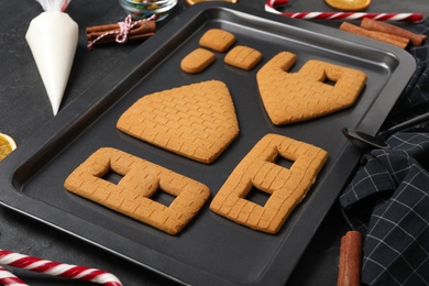 Photo of Parts of gingerbread house on black table, closeup