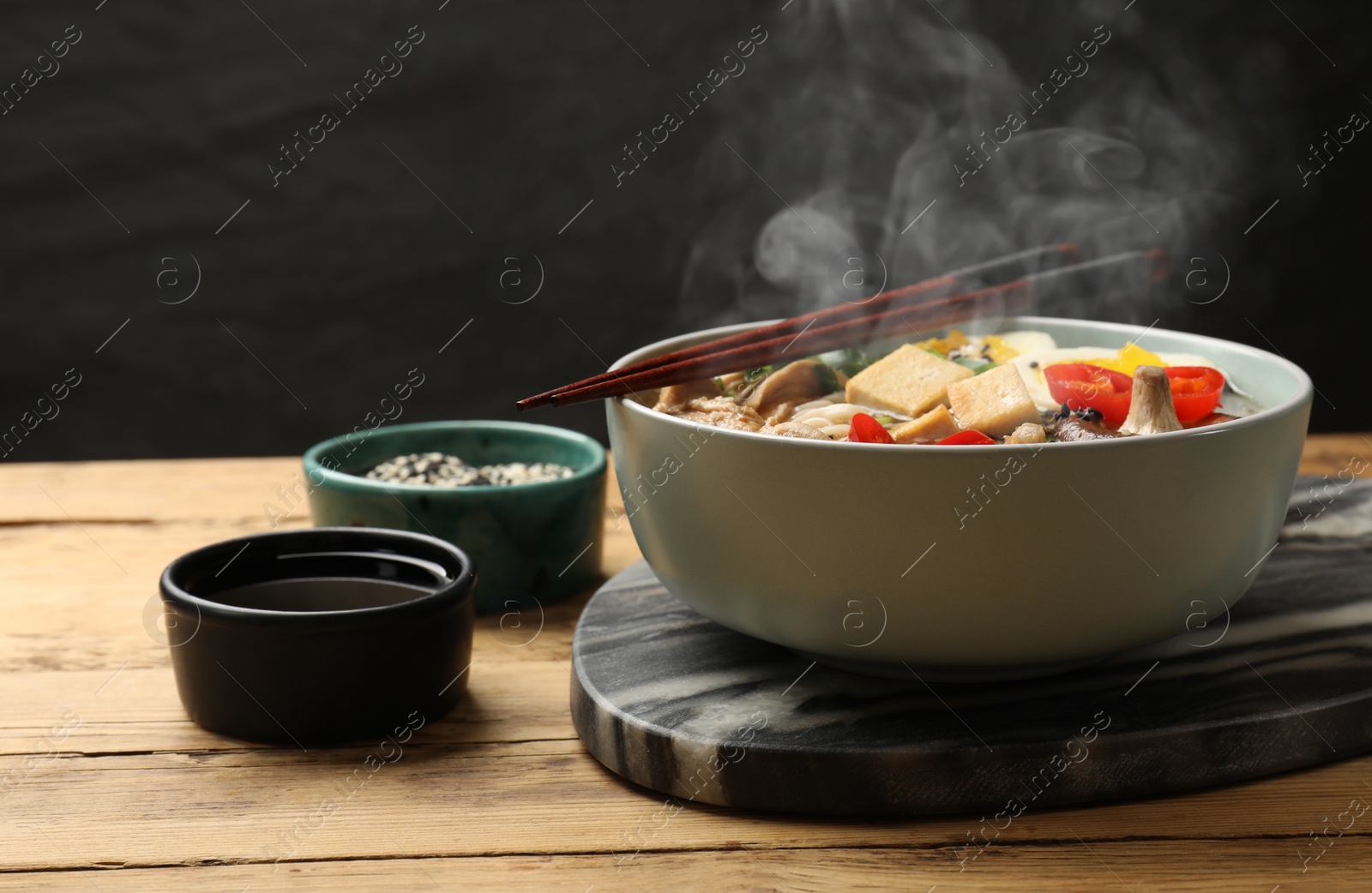 Image of Noodle soup. Bowl of hot ramen and chopsticks on wooden table