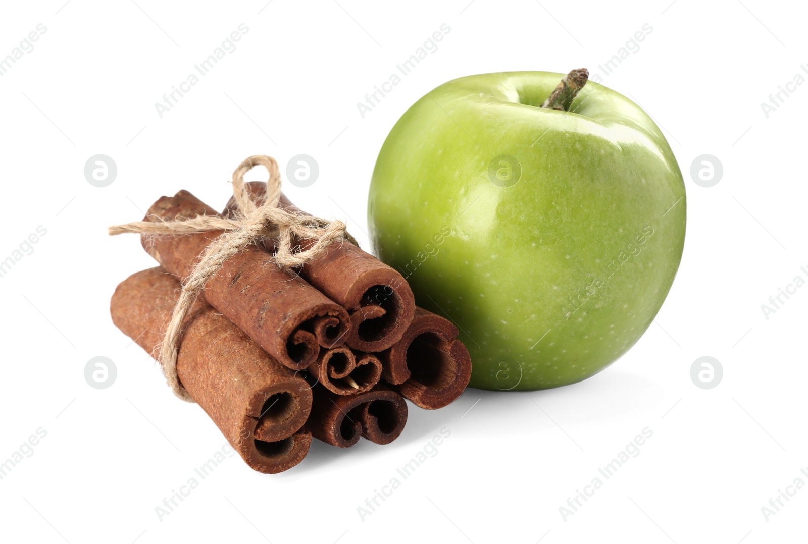 Photo of Cinnamon sticks and green apple on white background